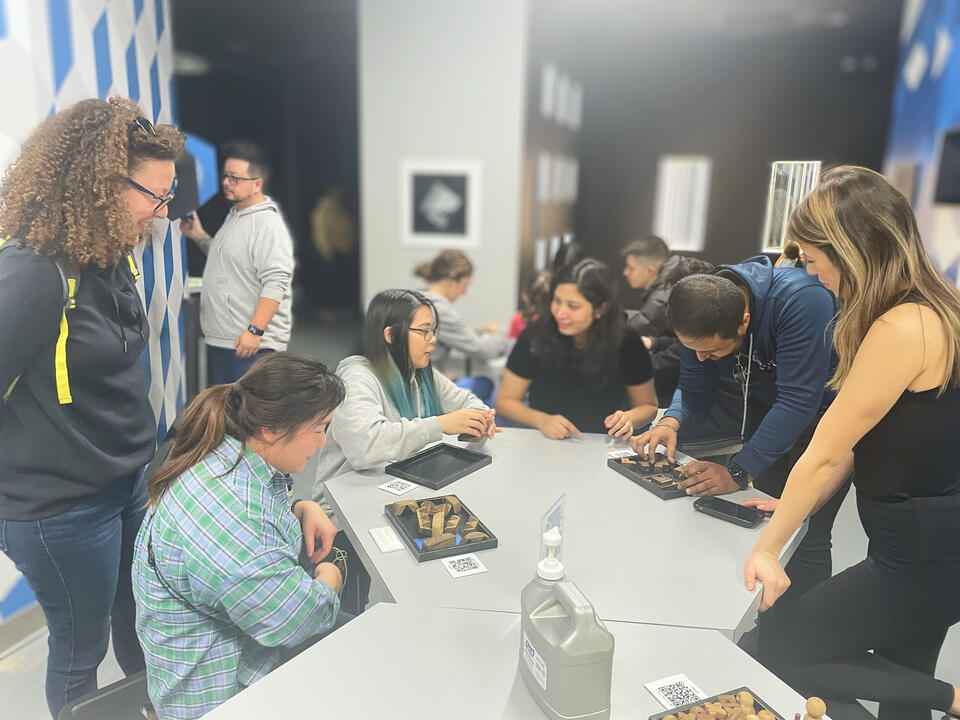 Rendezvoux members collaborating around a workshop table.